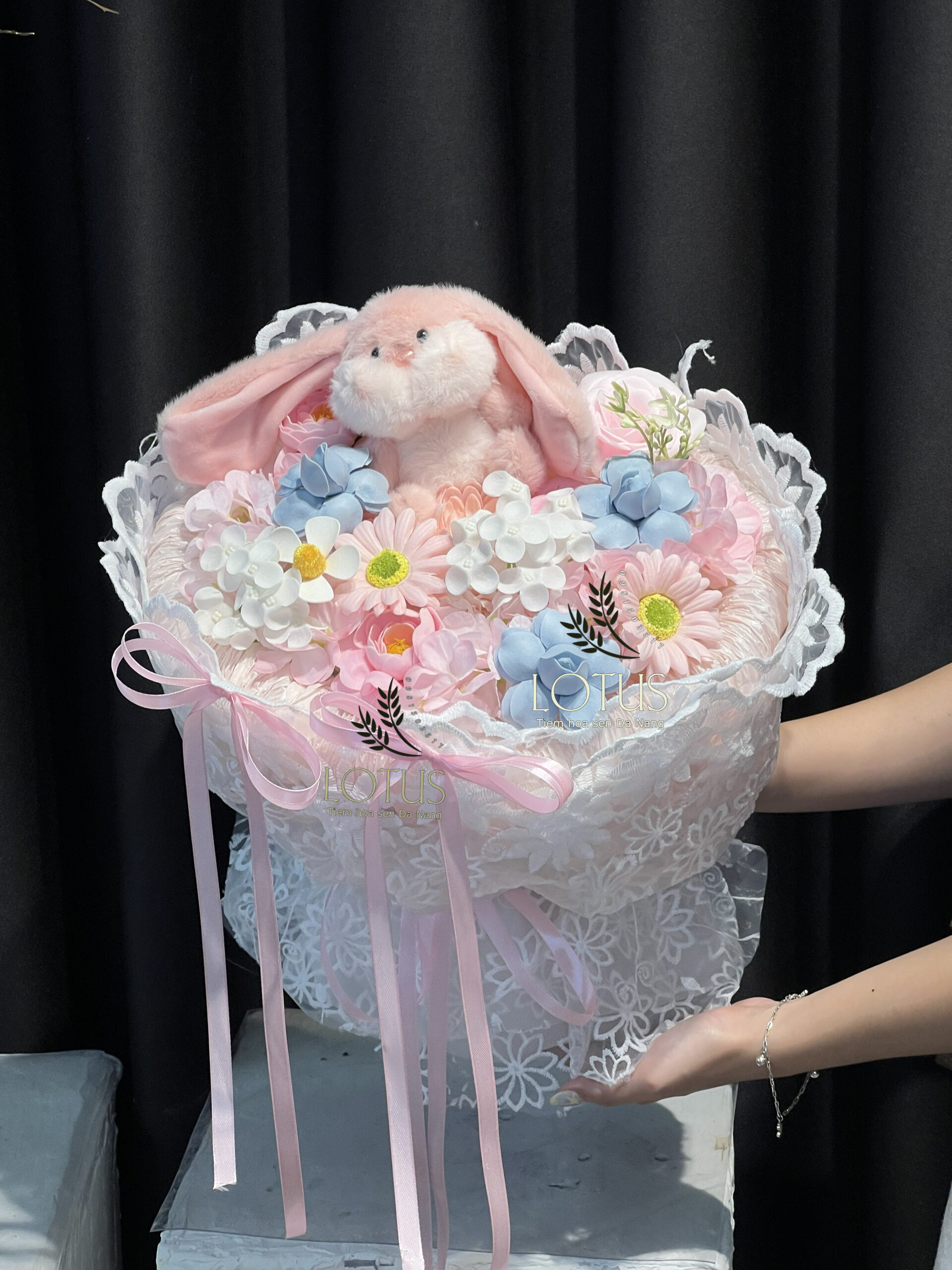 Bó hoa sáp thỏ bông hồng phối voan ren trắng và nơ pastel