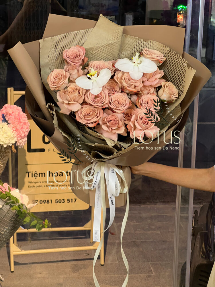 Bó hồng Capuchino phối lan hồ điệp trắng, gói giấy nâu và giấy tổ ong.